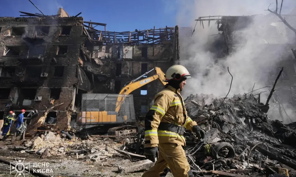 Bombero del Servicio Estatal de Emergencias de Ucrania junto a un edificio residencial destruido en Kiev tras el ataque masivo ruso del 24 de mayo