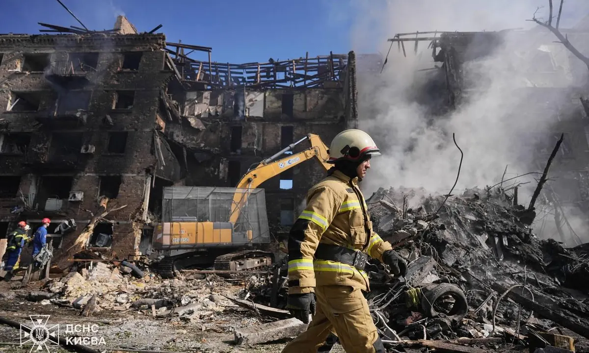 Bombero del Servicio Estatal de Emergencias de Ucrania junto a un edificio residencial destruido en Kiev tras el ataque masivo ruso del 24 de mayo