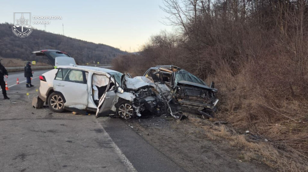Escena de accidente tráfico mortal con vehículos accidentados y señalización de emergencia en la carretera