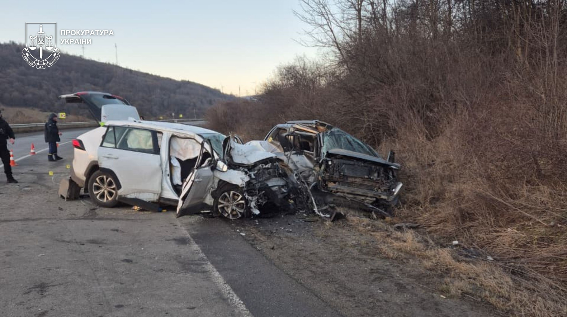 Escena de accidente tráfico mortal con vehículos accidentados y señalización de emergencia en la carretera