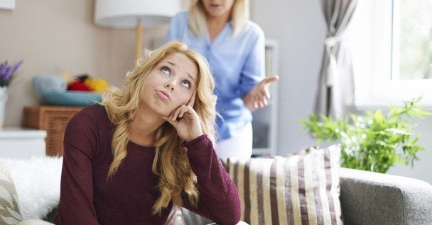 Madre e hijo adulto conversando con tensión sobre límites y comunicación familiar