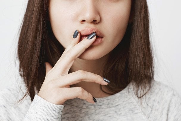 Persona con queilitis angular mostrando grietas y rojez en las comisuras de los labios