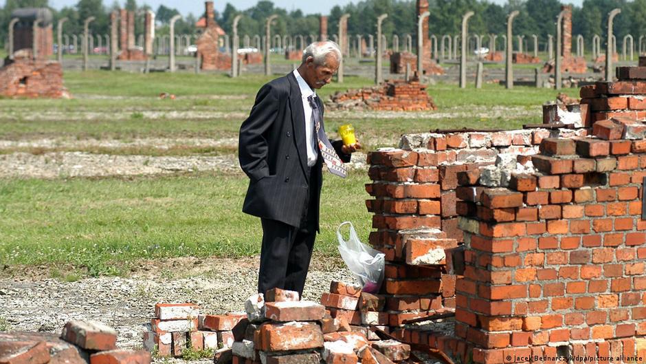 Monumento conmemorativo del Holocausto romaní en Europa del Este con flores y velas en memoria de las víctimas