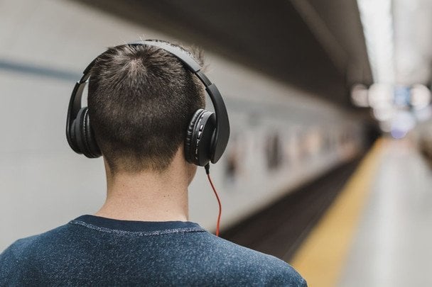 Persona escuchando música heavy metal para soportar el dolor con auriculares puestos