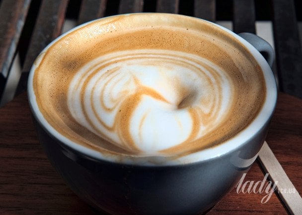 Taza de café con limón recién preparado sobre una mesa de madera por la mañana