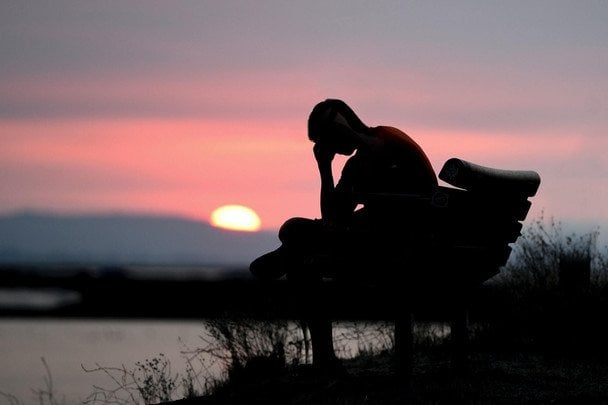 Persona mirando el atardecer de verano con nostalgia, síndrome verano perdido