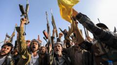Combatientes hutíes Yemen en formación militar con banderas del movimiento