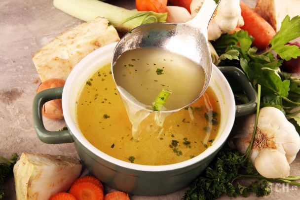 Caldo dorado casero en olla con verduras y especias para conseguir un color intenso y apetecible