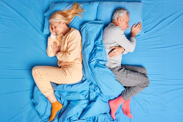 Pareja mayor en proceso de divorcio tardío tras jubilarse sentada en lados opuestos del sofá